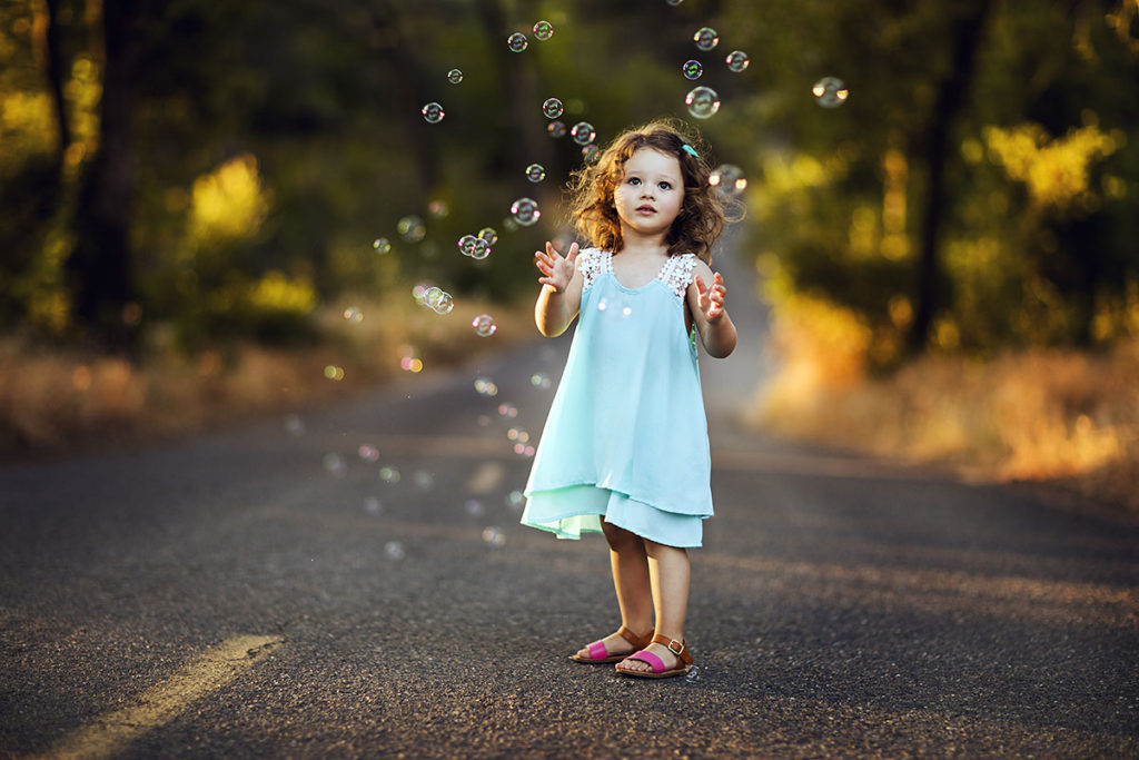 Little girl with bubbles during summer kids photoshoot
